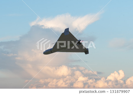 A modern drone in flight against the sunset sky. A modern drone in flight against the sunset sky. 131879907