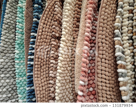 There are small soft rugs hanging in the shop window There are small soft rugs hanging in the shop window 131879934
