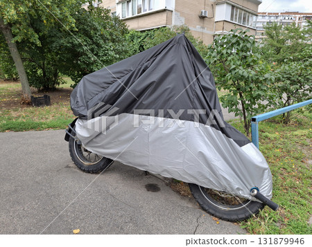 Cover on a motorcycle parked near a house 131879946