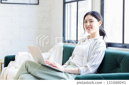 在客廳裡扮演個人電腦的年輕女士 131880041