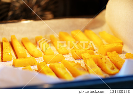 Cooking Baked pumpkin slices with cinnamon and honey on a baking sheet in the oven. Autumn food. Vegan dessert, healthy food. Close up, selected focus style Cooking Baked pumpkin slices with cinnamon and honey on a baking sheet in the oven. Autumn food. Vegan dessert, healthy food. Close up, selected focus style 131880128