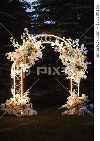Wedding floral arch with white and pink flowers in garden at sunset 131880158
