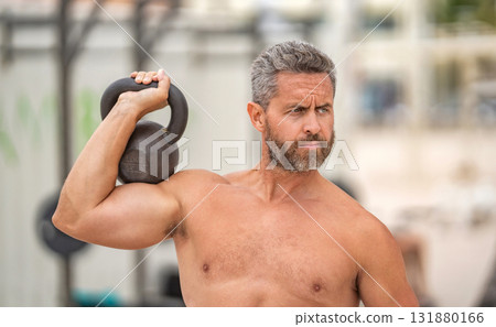 Sport athlete man hold kettlebell. Weightlifting kettlebell training. Hispanic man exercising with kettlebell outdoor. Man athlete lifting kettlebell. Athletic man do sport exercise. Gym workout Sport athlete man hold kettlebell. Weightlifting kettlebell training. Hispanic man exercising with kettlebell outdoor. Man athlete lifting kettlebell. Athletic man do sport exercise. Gym workout 131880166