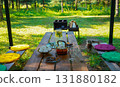 The summer breeze gently moves the tablecloth, while the tea set awaits guests for a delightful outdoor tea experience. 131880182