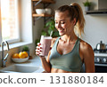 Woman with a homemade green detox juice, wearing sportive clothing 131880184