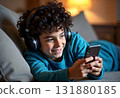 Child boy using digital tablet and headphones on the sofa in living room. 131880185