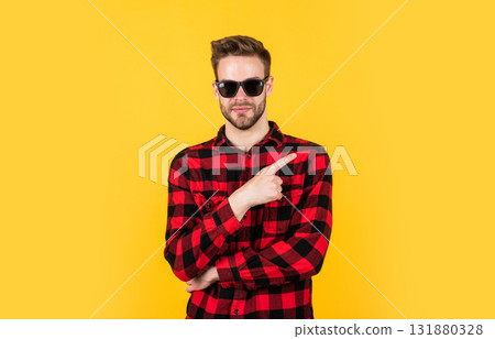 pointing finger. barbershop concept. mens wear. young handsome guy in checkered shirt and glasses. stylish male wear casual clothes. bearded man with bristle on unshaven face. fashion and beauty pointing finger. barbershop concept. mens wear. young handsome guy in checkered shirt and glasses. stylish male wear casual clothes. bearded man with bristle on unshaven face. fashion and beauty 131880328