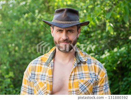 smiling macho man in cowboy hat. macho man in checkered shirt. western macho man wearing hat smiling macho man in cowboy hat. macho man in checkered shirt. western macho man wearing hat 131880392