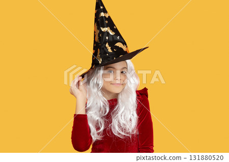 Teen girl in witch costume. Happy Halloween. Girl witch in Halloween costume isolated on yellow. Trick or treat. Celebrate All Hallows party holiday. All Hallows. October 31 Teen girl in witch costume. Happy Halloween. Girl witch in Halloween costume isolated on yellow. Trick or treat. Celebrate All Hallows party holiday. All Hallows. October 31 131880520
