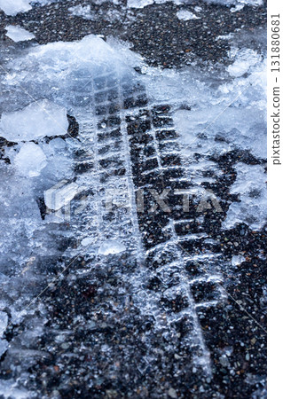 Tire marks on the frozen road surface_Vertical 131880681
