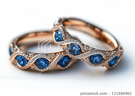 Luxurious pair of wedding rings with blue stones on a white background. Rococo-Renaissance style. 131880962