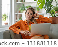 Middle-aged woman engaged in online communication via laptop expressing intensely focused and tensed 131881318