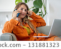 Middle-aged woman happily talking on phone having nice conversation during break from laptop work  131881323