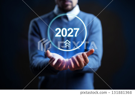 Technology and future predictions in 2027 by a businessman holding an hologram 131881368