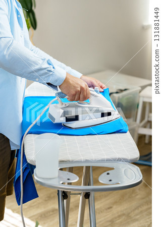 Ironing clothes at home in a cozy living space during daytime 131881449