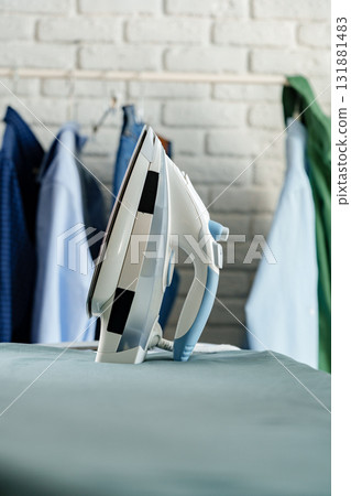 Iron prepared for ironing clothes in a home laundry area Iron prepared for ironing clothes in a home laundry area 131881483