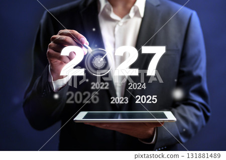 Business professional presenting future years with digital tablet and clock concept for 2027 Business professional presenting future years with digital tablet and clock concept for 2027 131881489