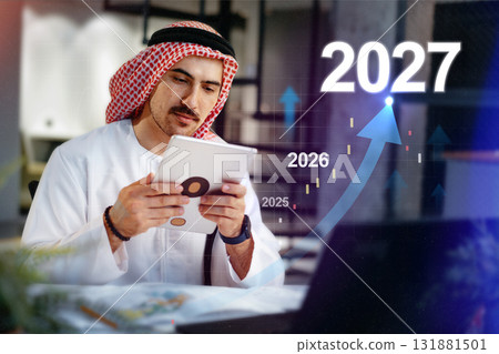 Man in traditional attire analyzes data trends for business growth until 2027 131881501