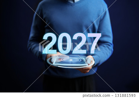 Future planning session showcasing technology in 2027 by an individual in a blue sweater 131881593