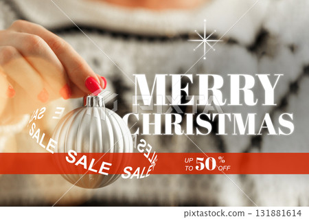 Holiday season sale with a hand holding a Christmas ornament and festive decoration 131881614