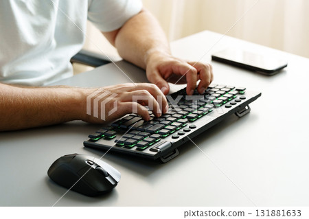 Typing on a modern keyboard while using a computer mouse in a bright office setting Typing on a modern keyboard while using a computer mouse in a bright office setting 131881633