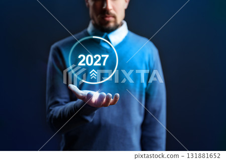 Man holding a futuristic display showing the year 2027 in a technology-themed setting 131881652
