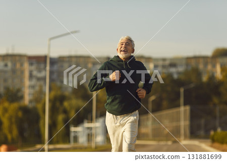 Happy joyful senior man running on city street during his outdoor sports workout Happy joyful senior man running on city street during his outdoor sports workout 131881699