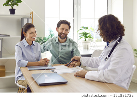 Young married couple signs contract with doctor in modern obstetrics and gynecology clinic. Young married couple signs contract with doctor in modern obstetrics and gynecology clinic. 131881722