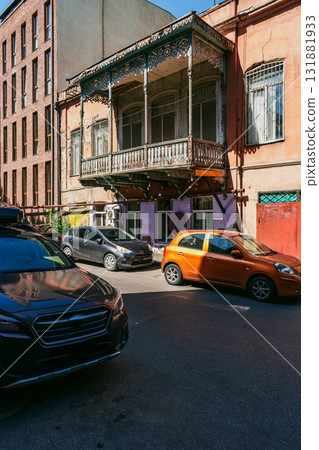 Historic building with balcony and vibrant street activity in urban area on sunny day Historic building with balcony and vibrant street activity in urban area on sunny day 131881933