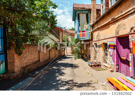 Colorful street in a historic neighborhood filled with vibrant art and greenery during a sunny day 131882002