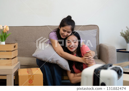 Loving LGBTQ couple embracing on the couch while moving into their new home 131882474
