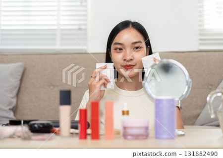 Makeup and Self-Confidence. A woman showcases her favorite cosmetics while preparing her look with a cheerful expression. Makeup and Self-Confidence. A woman showcases her favorite cosmetics while preparing her look with a cheerful expression. 131882490