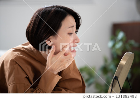 Woman checking her teeth in a mirror 131882498
