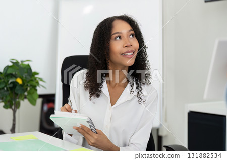 Business Insights and Sustainability Efforts. A woman taking notes during a presentation on ESG practices. 131882534