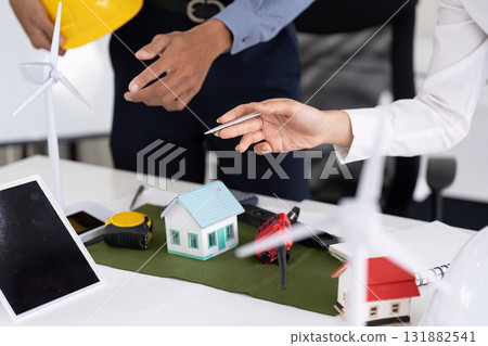 Sustainable Engineering Practices. Engineers collaborating on green housing projects and renewable energy solutions. 131882541