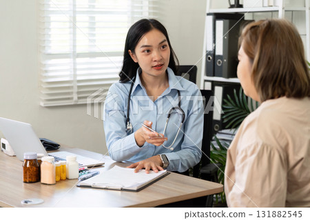 Healthcare and Patient Communication. A healthcare professional engages in a detailed consultation with a patient about health concerns. 131882545