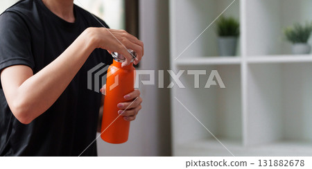 Hydration and Health. A person preparing to drink from a vibrant, reusable water bottle. Hydration and Health. A person preparing to drink from a vibrant, reusable water bottle. 131882678