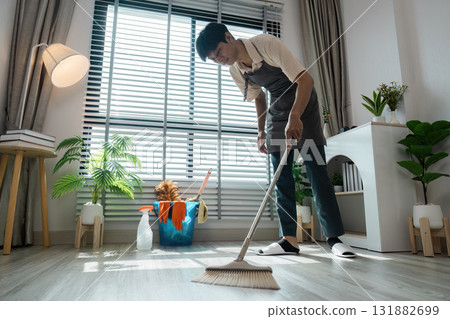 Home Cleaning and Organization. A skilled individual meticulously sweeping the floor, contributing to a well-maintained home environment. Home Cleaning and Organization. A skilled individual meticulously sweeping the floor, contributing to a well-maintained home environment. 131882699