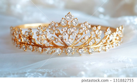 Golden Tiara Adorned with Jewels Resting on White Fabric. Golden Tiara Adorned with Jewels Resting on White Fabric. 131882755