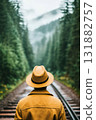 Traveler stands along railway tracks within dense forest, seeking adventure. 131882757
