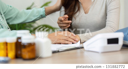 Medical Consultation and Patient Interaction. An elderly doctor engaging a patient with care and attentiveness during a consultation. 131882772
