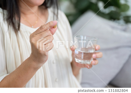Medication Routine and Wellness. An elderly woman preparing to take her daily vitamins. 131882804