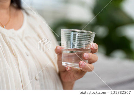 Hydration and Daily Health. An elderly woman drinking water for her health. 131882807