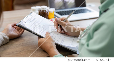 Patient Records and Healthcare Management. Doctor filling out medical records during consultation. Patient Records and Healthcare Management. Doctor filling out medical records during consultation. 131882812
