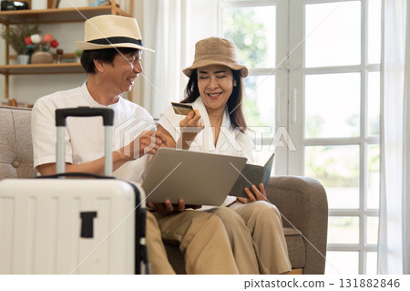 Seniors and Digital Travel Planning. A couple reviewing international travel options on their laptop before their trip. 131882846