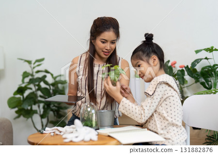 Caring for Plants Together. A mother and daughter explore the joys of plant care in a sustainable indoor setting. Caring for Plants Together. A mother and daughter explore the joys of plant care in a sustainable indoor setting. 131882876