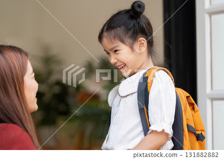 Smiles and Confidence. A girl shares a heartfelt moment with her mother before leaving for school. 131882882