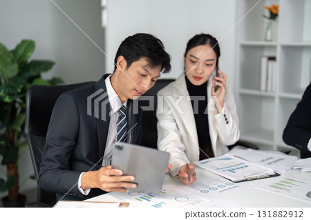 Business Meeting and Discussion. Two professionals analyzing market data and strategies in a modern office environment. 131882912