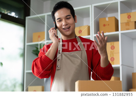 Customer Interaction and Business Growth. A young entrepreneur engaged in a phone conversation, enhancing customer service and satisfaction. Customer Interaction and Business Growth. A young entrepreneur engaged in a phone conversation, enhancing customer service and satisfaction. 131882955