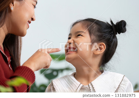 Joyful Communication and Love. A mother lovingly engages with her daughter as she prepares for school. Joyful Communication and Love. A mother lovingly engages with her daughter as she prepares for school. 131882975
